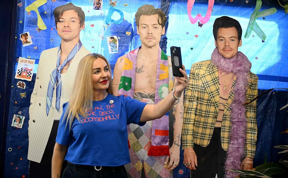 Una persona se toma una foto frente a fotos de Harry Styles en la estación de tren de Holmes Chapel, al noroeste de Inglaterra.
Foto de Oli SCARFF / AFP.