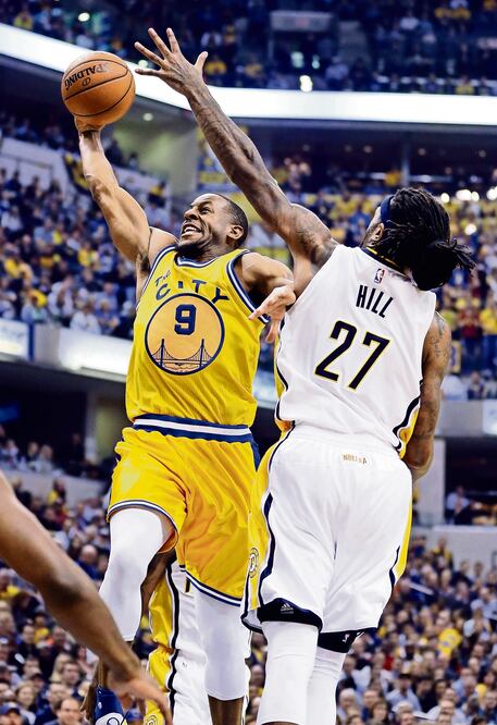 Andre Iguodala (9) sume el balón ante la marca de Jordan Hill, de Pacers (MICHAEL CONROY. AP)