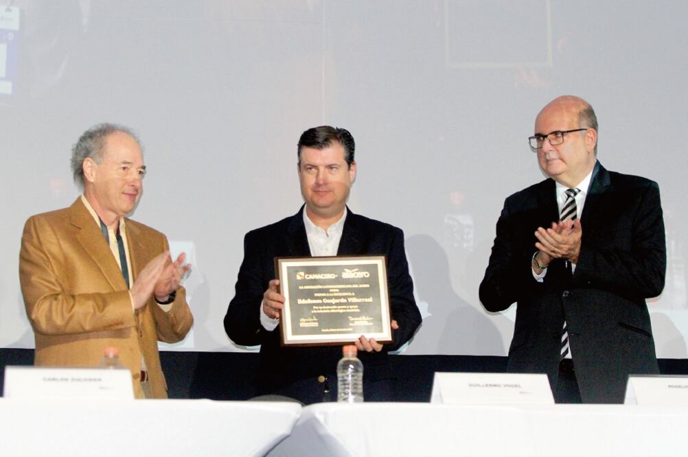 Guillermo Vogel (primero de izq. a der.), presidente de la Canacero, al entregar el reconocimiento a Rogelio Garza Garza, subsecretario de Industria y Comercio. (CORTESÍA)