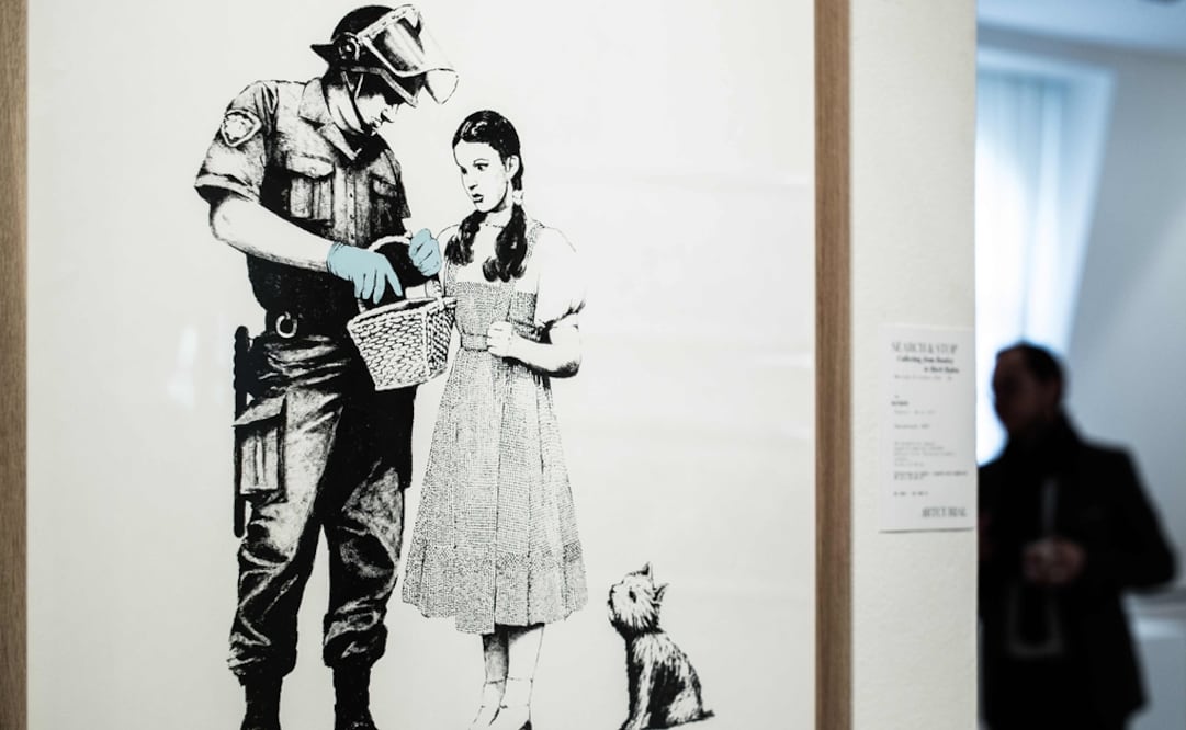 Un hombre está cerca de la obra de Banksy "Stop and Search". Foto: Philippe Lopez / AFP