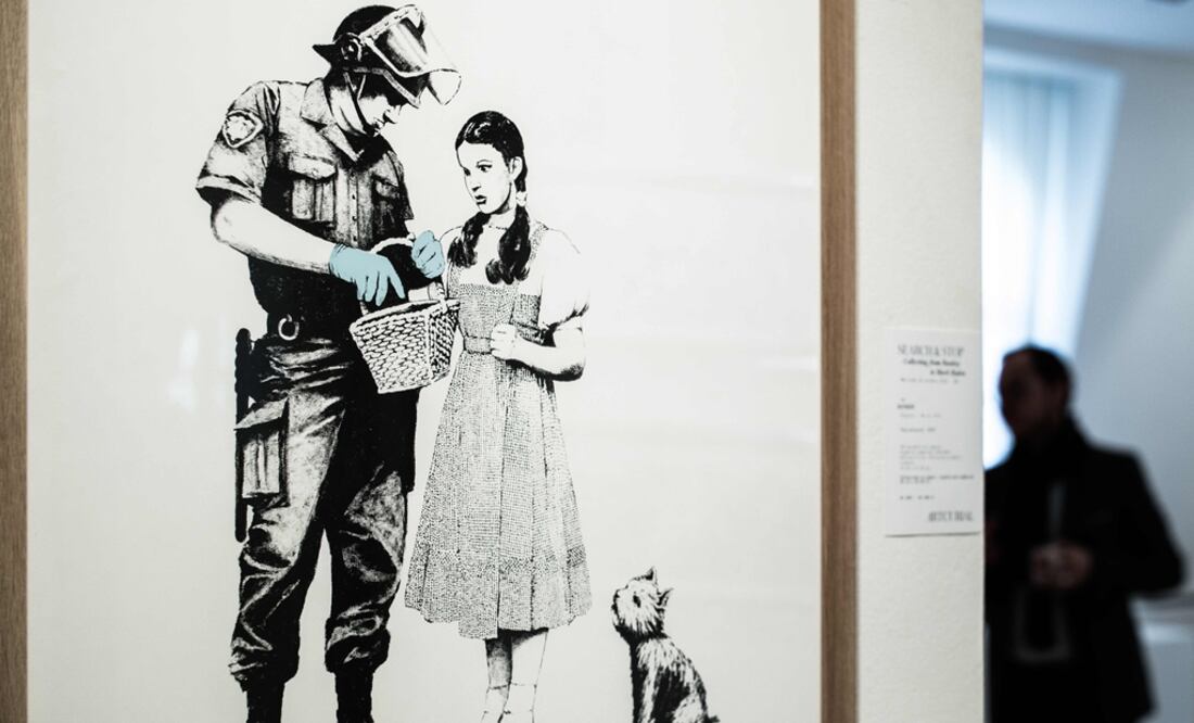 Un hombre está cerca de la obra de Banksy "Stop and Search". Foto: Philippe Lopez / AFP