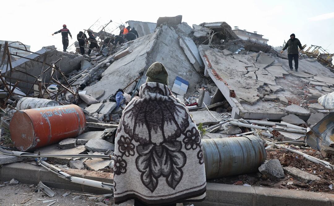 Un hombre mira mientras los rescatistas y los civiles buscan sobrevivientes bajo los escombros de los edificios derrumbados en Kahramanmaras, cerca del epicentro del terremoto. Foto: AFP 