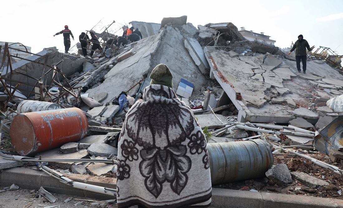 Un hombre mira mientras los rescatistas y los civiles buscan sobrevivientes bajo los escombros de los edificios derrumbados en Kahramanmaras, cerca del epicentro del terremoto. Foto: AFP
