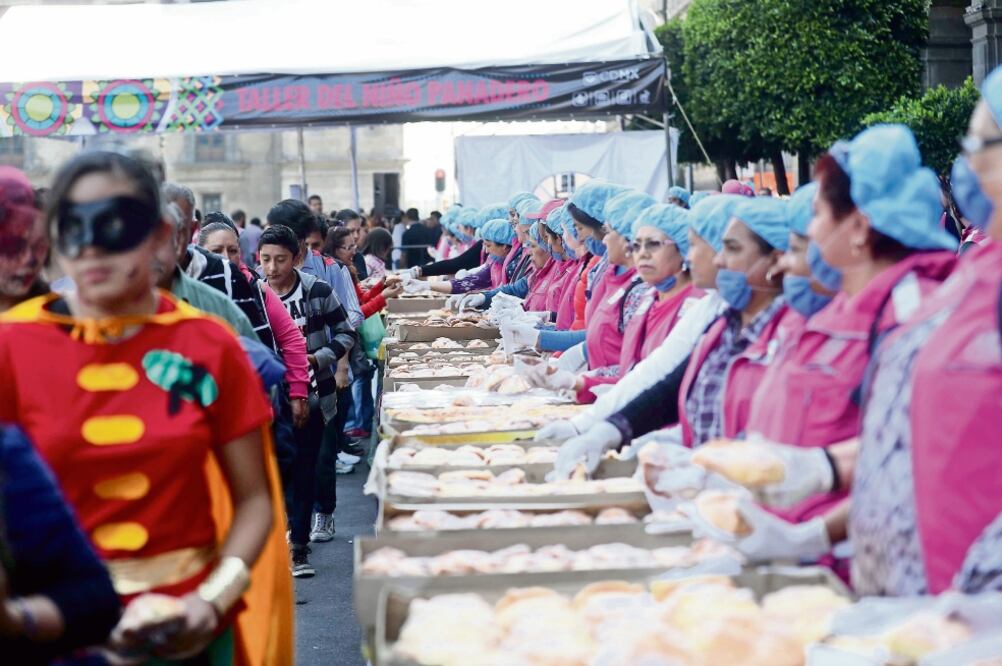 Vistantes de la mega ofrenda del Zócalo recibieron con sorpresa el regalo de una pieza del tradicional pan de muerto. La Cámara Nacional de la Industria Panificadora entregó en total 30 mil piezas de este manjar (FERNANDO RAMÍREZ)