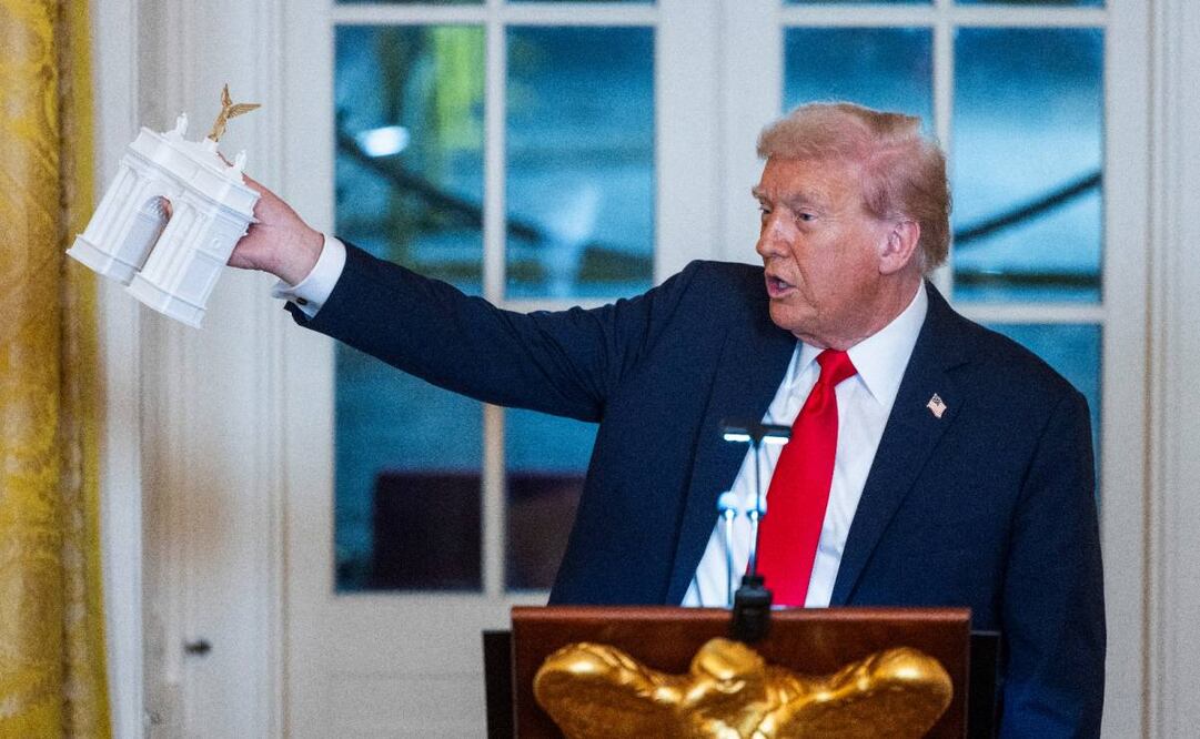 El presidente de Estados Unidos, Donald Trump sostiene una maqueta del Arco del Triunfo durante la recepción en la Casa Blanca. (16/10/25) Foto: EFE