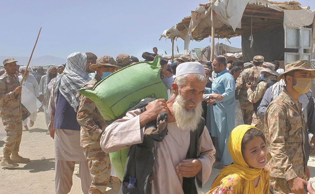 Soldados paquistaníes, mientras personas caminan hacia el lado afgano en el cruce fronterizo, en Chaman. Foto: Jafar Khan/ AP.