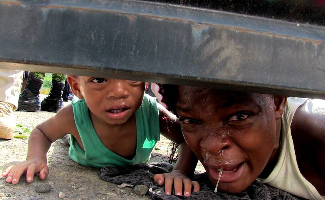 En un centro de detención del INM en Tapachula, Fabiola, procedente de Haití, clamaba por debajo del portón por ayuda para su hijo enfermo. Foto: MARÍA DE JESÚS PETERS. EL UNIVERSAL