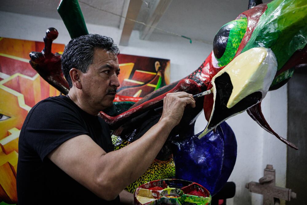 Brochazo a brochazo, Manuel llena de color a su alebrije llamado Cuicatl o canto florido en náhuatl, que mide 2.20 metros y combina elementos como una guitarra, por su gusto por el rock. Foto: Gabriel Pano | El Universal