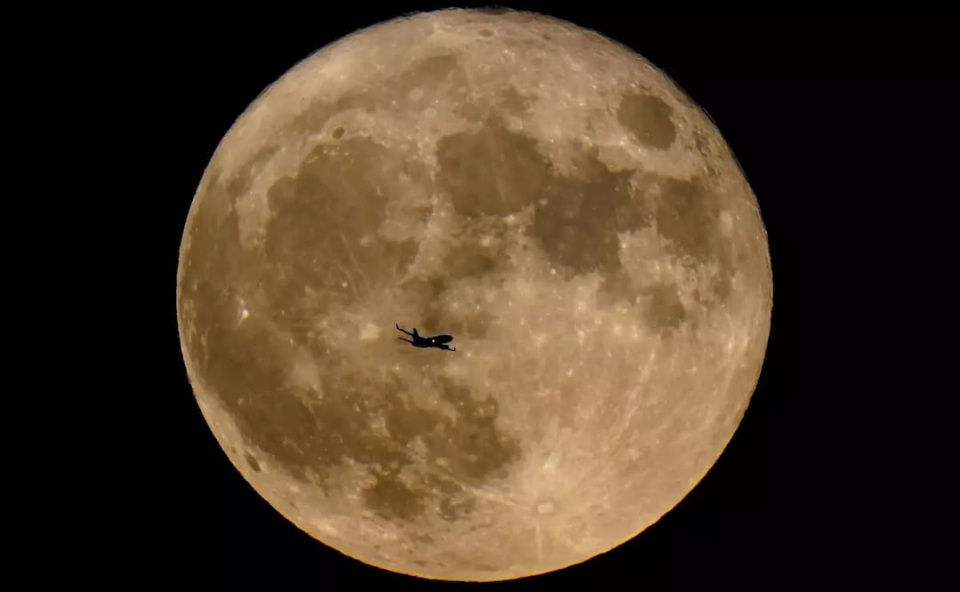 Un avión pasa frente a una superluna, el 13 de julio de 2022, en Milwaukee. Foto: AP