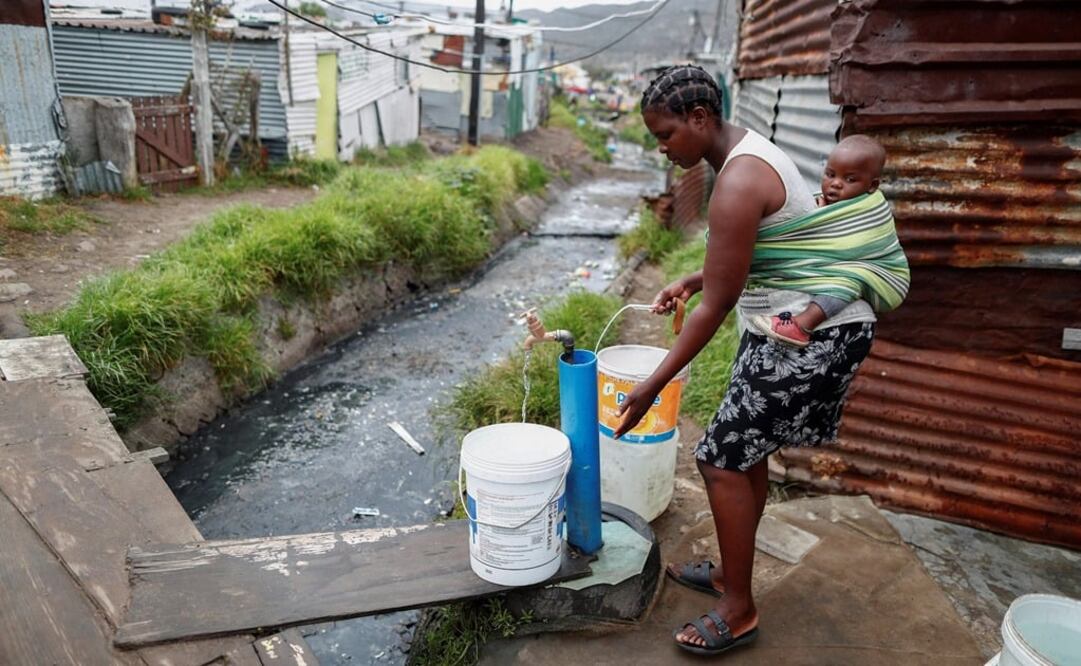 Una mujer recolecta agua de un grifo comunitario en Ciudad del Cabo en Sudáfrica (Foto: EFE)