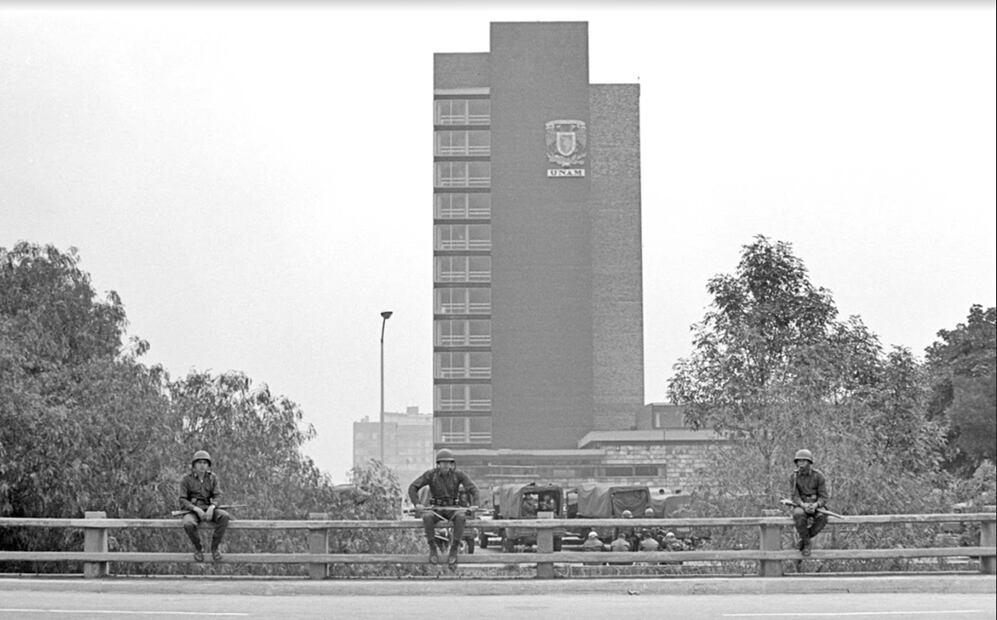 Tres soldados miran fijamente a la cámara del fotógrafo Bob Schalkwijk en las inmediaciones de la Ciudad Universitaria, en 1968. A sus espaldas se aprecian varias unidades del Ejército instaladas a unos pasos de la Torre de Rectoría. Imagen cortesía:  Bob Schalkwijk