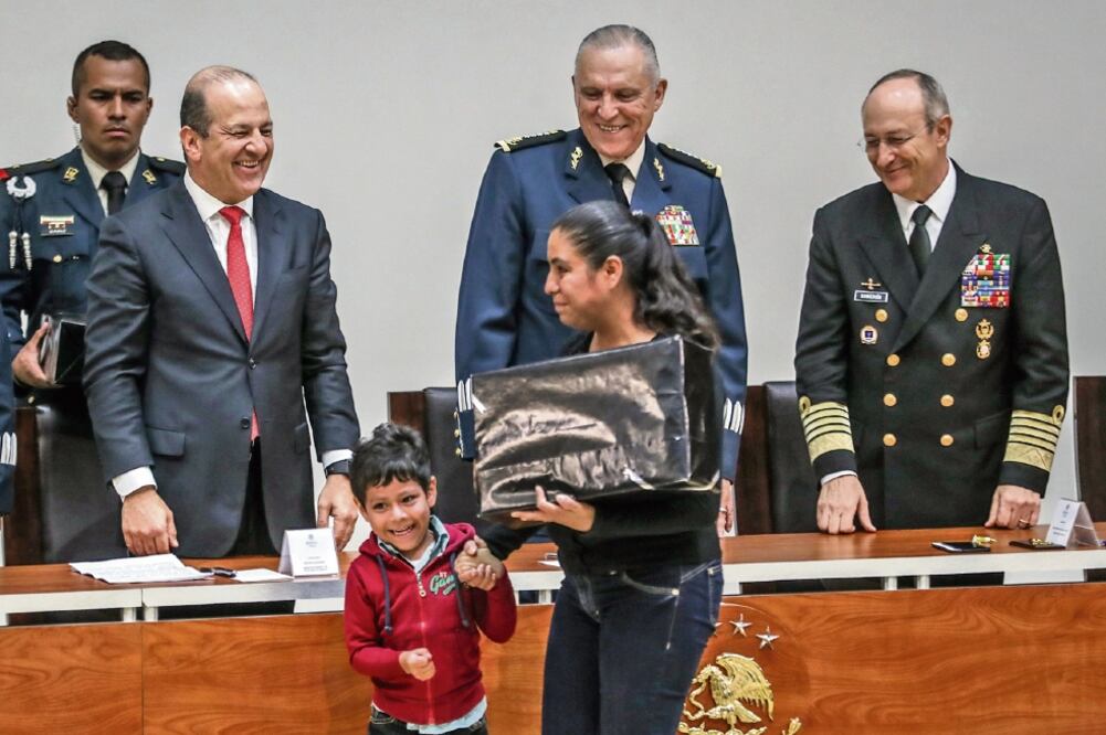 Héctor Slim, director de Telmex (izq.), y Salvador Cienfuegos, titular de la Sedena (centro), entregaron computadoras a hijos de elementos caídos. Los acompaña Vidal Francisco Soberón, secretario de Marina. Foto: GERMÁN ESPINOSA. EL UNIVERSAL