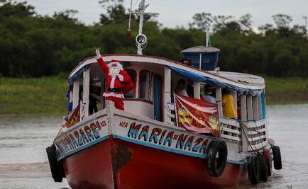 Sobre una lancha, Santa Claus reparte regalos a niños pobres en Brasil