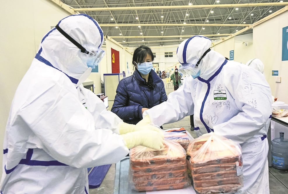 Trabajadores de la salud distribuyen comida en el "Wuhan Livingroom". Foto: Xinhua/Xiong Qi, archivo