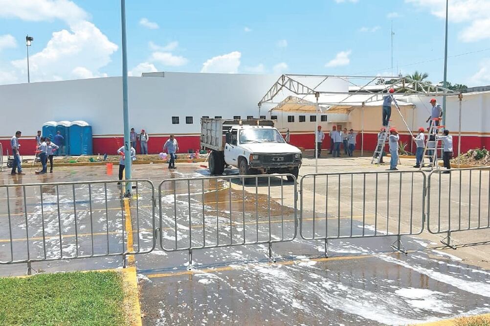 Preparativos. Personal comenzó a lavar el estacionamiento de la Siglo XXI y colocó sanitarios móviles. Foto/ESPECIAL