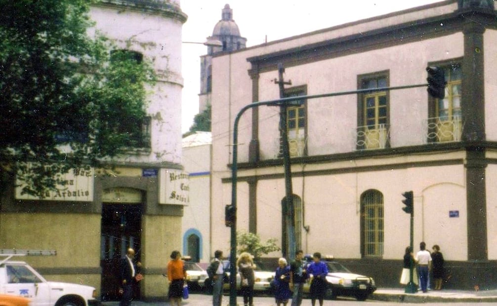 La esquina de José María Vigil y la avenida Revolución, en Tacubaya, en los años noventa. A la derecha está el edificio del registro civil, con el reloj que antes fue parte del antiguo Mercado de la Paz, demolido en los años cincuenta; a la izquierda se ve el restaurante bar Ardalio, que aún existe, y en el fondo se asoma la torre del templo de la Candelaria. Imagen: Colección Villasana.
