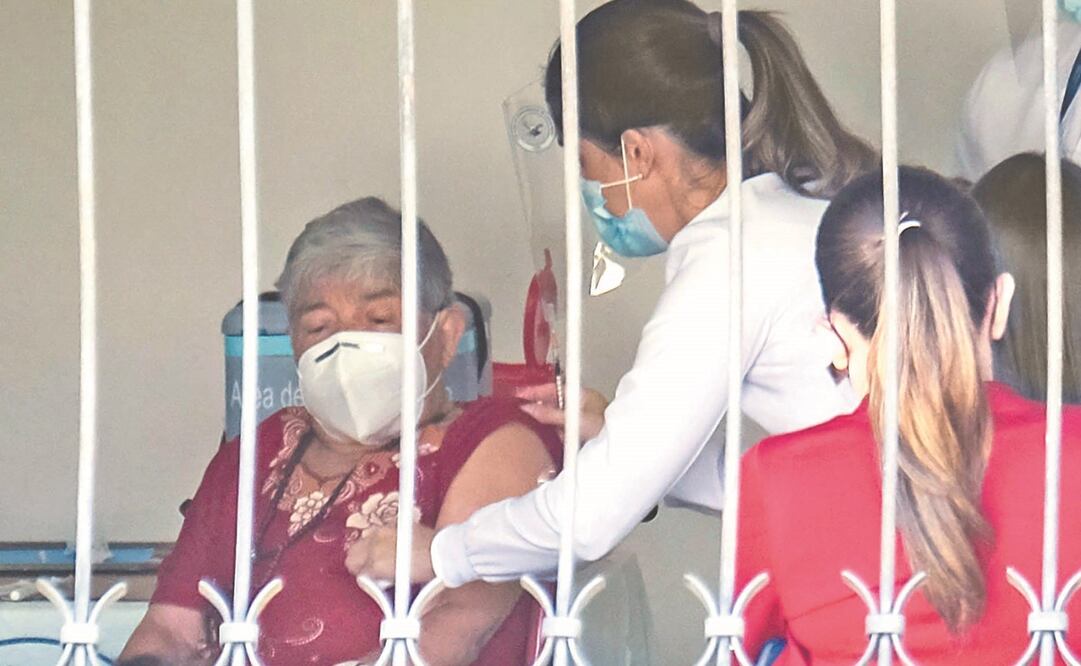 Personal del Ministerio de Salud atiende a Elizabeth Castillo, quien fue la primera persona en ser vacunada contra el Covid-19, el 24 de diciembre de 2020, en San José, Costa Rica. Foto: Jeffrey Arguedas. EFE