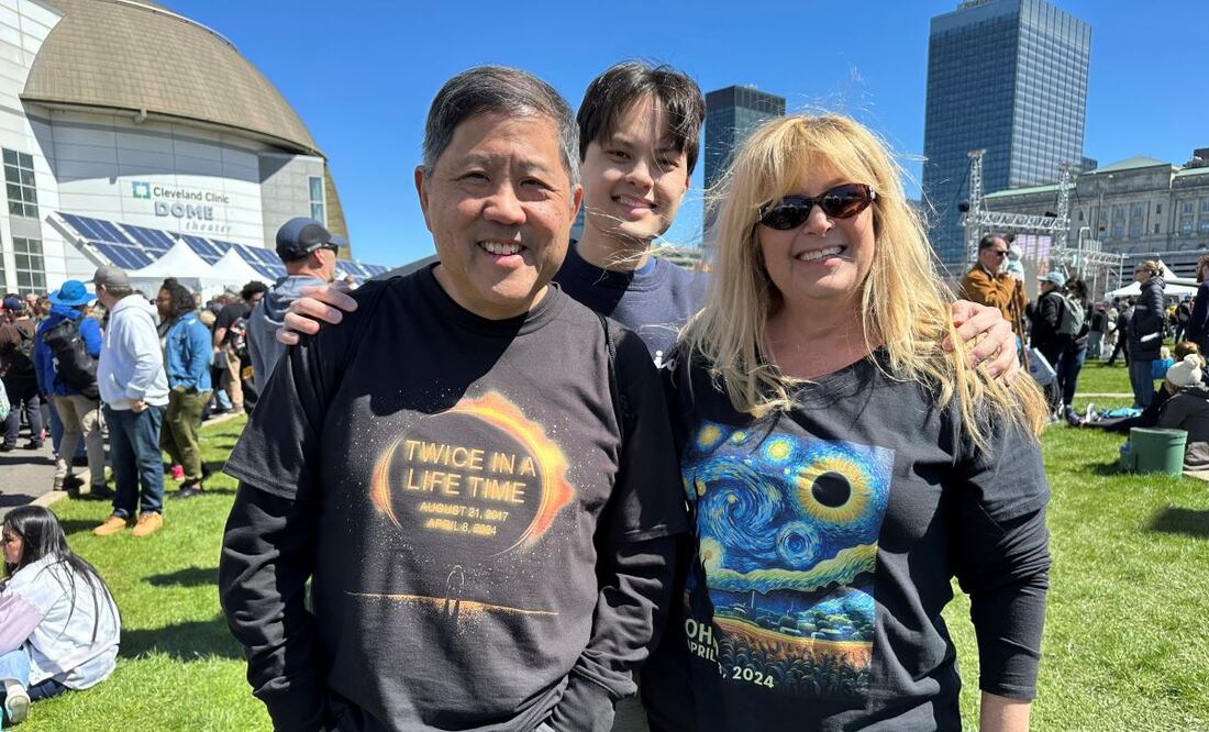 Anthony Tam, con una playera que dice: "Dos veces en la vida", acompañado por su familia, en el Centro de Ciencias de los Grandes Lagos, en Cleveland. Anthony vio el eclipse de 2017 e Casper, Wyoming, y viajó a Cleveland con su esposa Tamara, porque su hijo Joshua estudia en este estado. FOTO: AP
