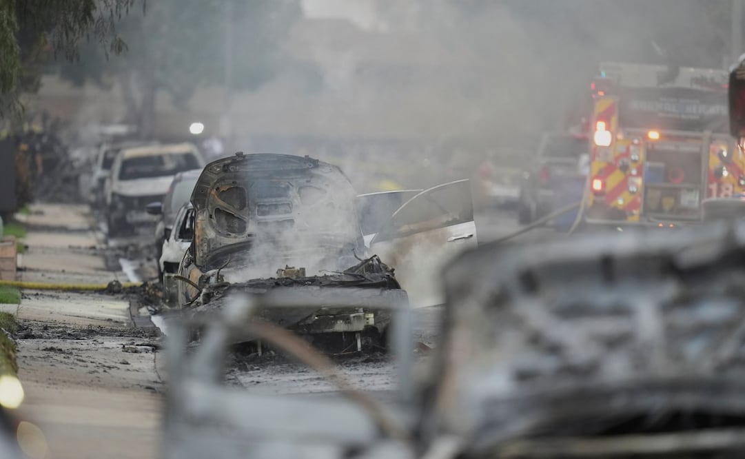 Vehículos sufren daños mientras las autoridades trabajan en el lugar donde una avioneta se estrelló en un vecindario de San Diego, incendiando varias casas y obligando a evacuaciones a lo largo de varias cuadras la madrugada del jueves 22 de mayo de 2025. Foto: AP