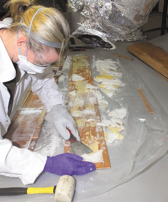 Una agente australiana remueve metanfetamina de una madera, en un almacén en Melbourne, en 2017. AFP