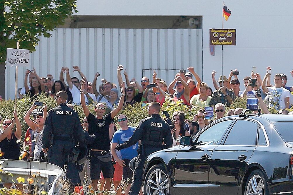Más de 100 manifestantes abuchearon a Merkel en Heidenau. Decenas de policías resultaron heridos cuando una turba lanzó botellas y fuegos artificiales (AXEL SCHMIDT. REUTERS)