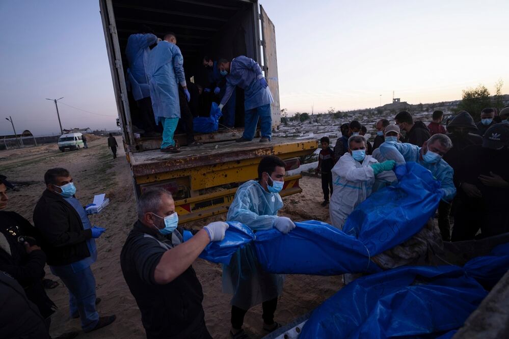 Los médicos descargan los cuerpos de palestinos muertos en combates con Israel y entregados por el ejército israelí durante un funeral masivo en Rafah. Foto: AP