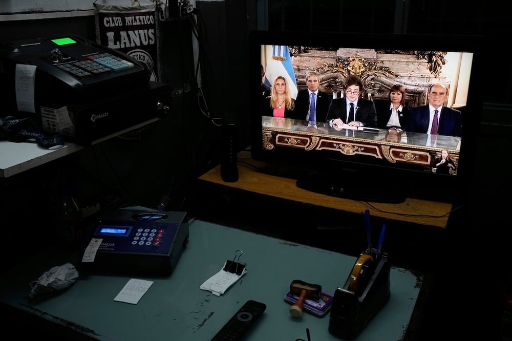 Una pantalla reproduce el discurso nacional del presidente Javier Milei, acompañado por miembros del gabinete, en Buenos Aires. Foto: AP