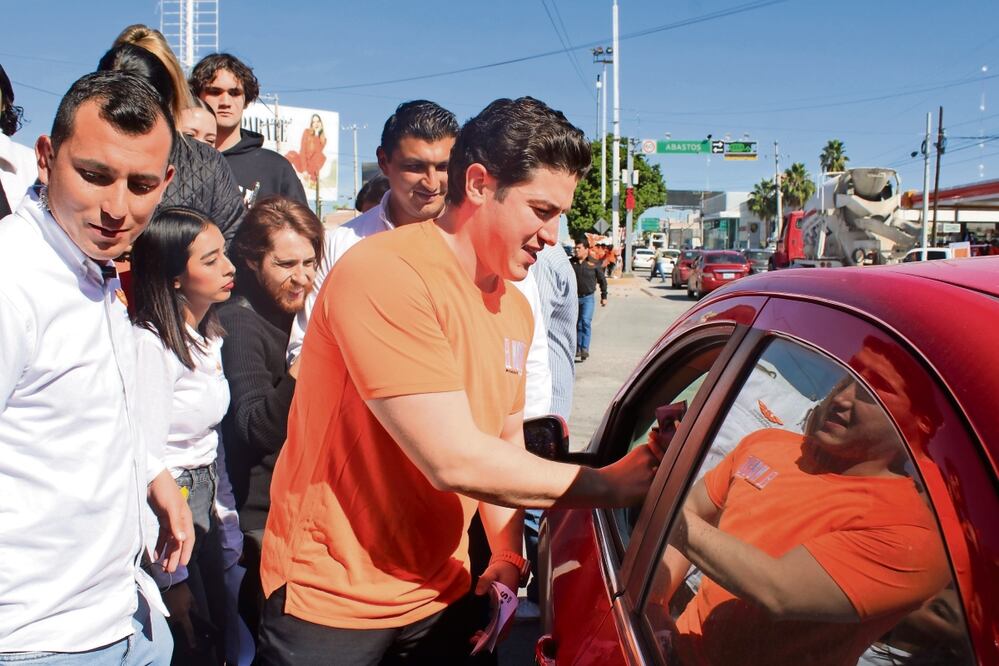 Samuel García repartió volantes y pegó calcas a los automovilistas en un crucero de Torreón, lo que provocó un caos vial. Foto: Especial