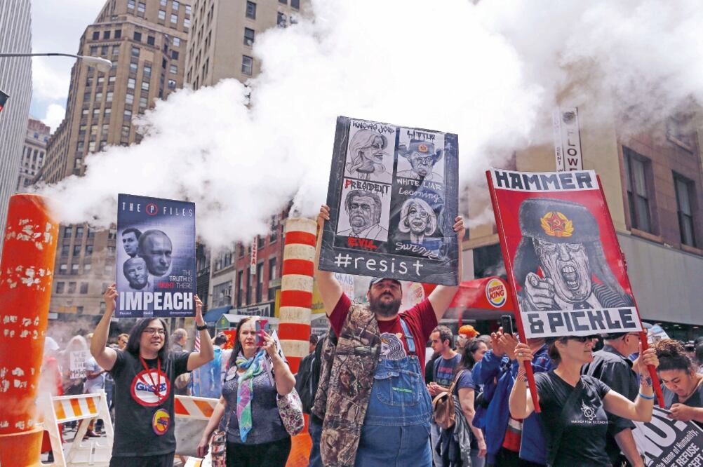 Manifestantes muestran carteles durante la “Marcha por la Verdad”, ayer, en Nueva York. Medios cifraron en unos 3 mil los participantes. (AFP)