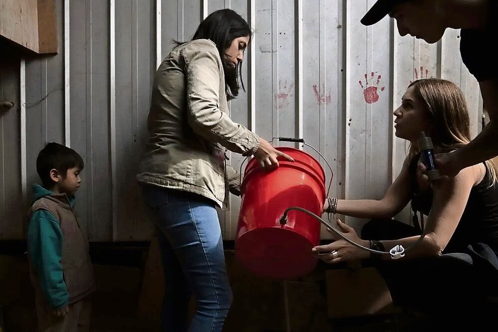 María José Terré (2-d), directora ejecutiva de Water is Life, muestra cómo funciona el sistema de filtros en una casa sin acceso a agua pura en el
campamento Parcela 11 de Forestal Alto, en la ciudad de Viña del Mar, en Chile. Foto: EFE