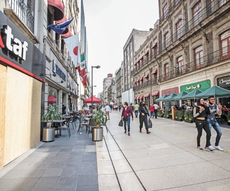 En las calles del primer cuadro de la Ciudad, las mesas que los restaurantes colocaron al aire libre dan vida, mientras que otros negocios permanecen cerrados. Foto: GERMAN ESPINOSA. EL UNIVERSAL