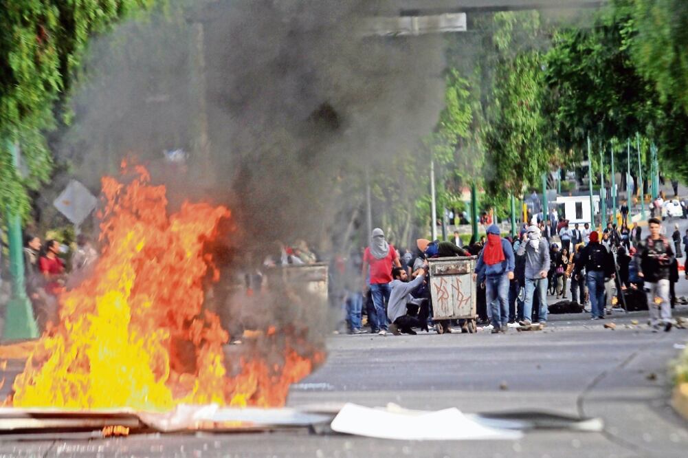 Personas con rostros cubiertos prendieron fuego a la basura que encontraron en la zona y realizaron pintas en los señalamientos de tránsito (FERNANDO RAMÍREZ. EL UNIVERSAL)