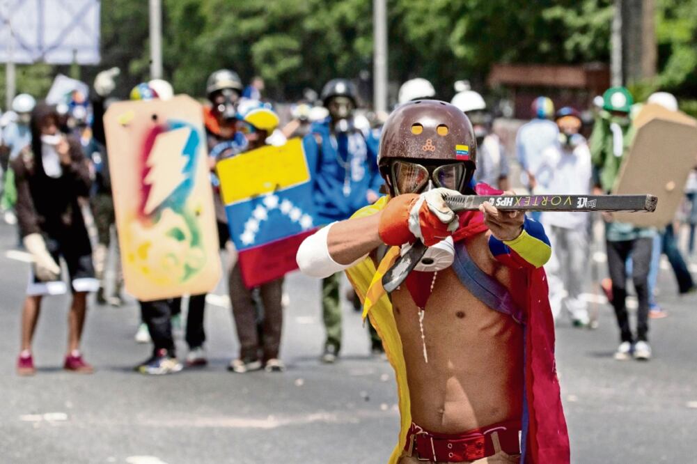 Manifestantes se enfrentan con la Guardia Nacional Bolivariana (GNB) durante una protesta opositora realizada ayer en Caracas y otras ciudades del país con el objetivo de pedir a los efectivos militares su apoyo. (MIGUEL GUTIÉRREZ. EFE)