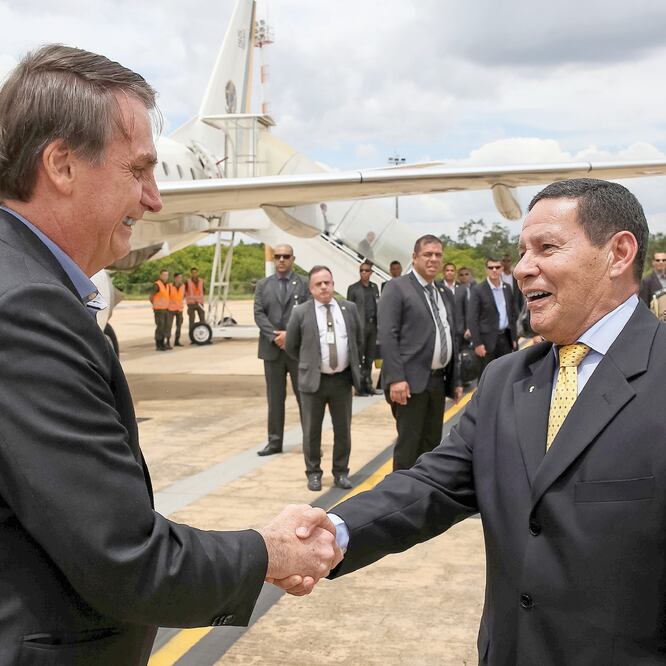 El presidente de Brasil, Jair Bolsonaro (izq.), saluda al vicepresidente Hamilton Mourao, el miércoles al llegar a Brasilia, tras ser dado de alta. REUTERS