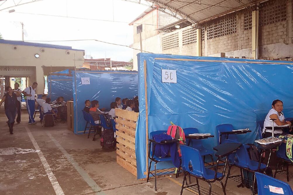 Tarimas cubiertas de hules y lonas que forman las paredes son los nuevos espacios para más de 300 alumnos de una plantilla de 649 estudiantes, quienes fueron reubicados en la explanada de la escuela Roberto Colorado. (EDWIN HERNÁNDEZ. EL UNIVERSAL)