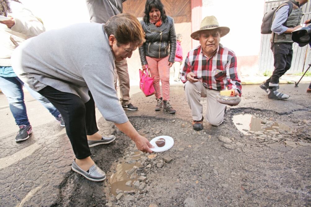 Vecinos de Capultitlán, en Toluca, le cantaron Las Mañanitas a un bache por un año más de existencia. El festejo incluyó globos, un cirio y pastelillos. (JORGE ALVARADO. EL UNIVERSAL)