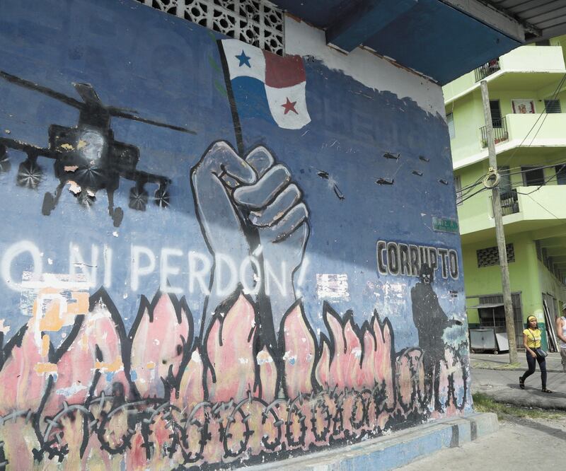 Panameños caminan por un mural contra la invasión estadounidense, en El Chorrillo, en Ciudad de Panamá. Foto/ARNULFO FRANCO. AP
