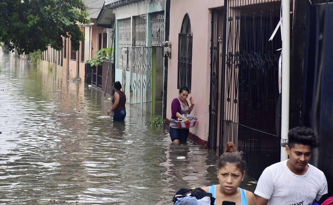 Habitantes caminan por una zona afectada tras las fuertes lluvias asociadas al paso de la tormenta "Eta" por Centroamérica (Fotos: EFE)