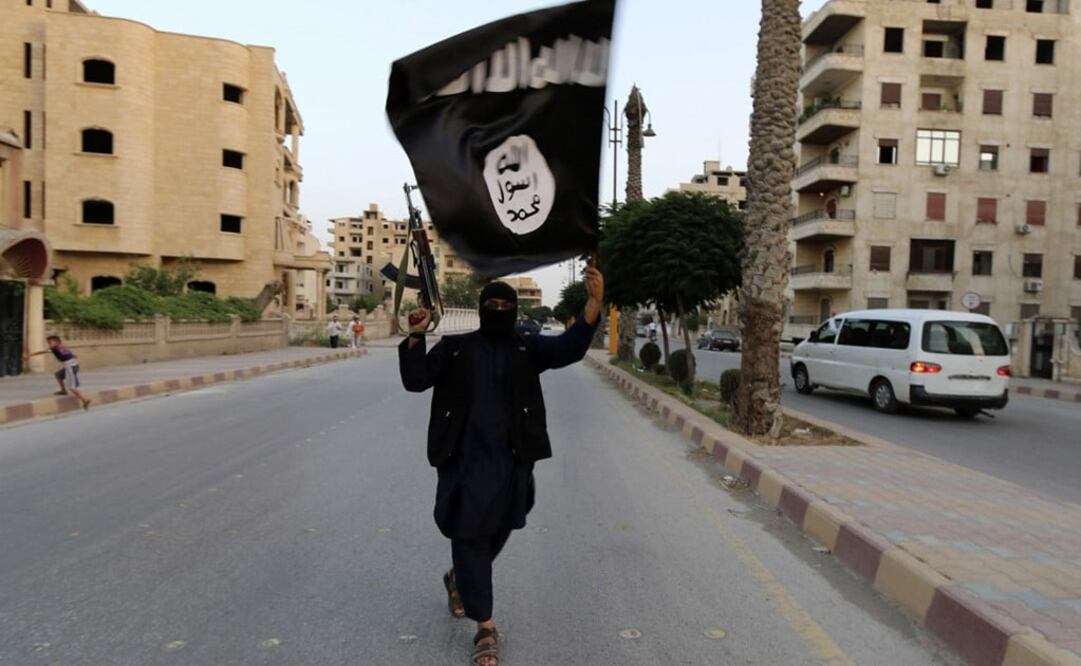 A member of the Islamic State waves an ISIL flag - Photo: Stringer/REUTERS