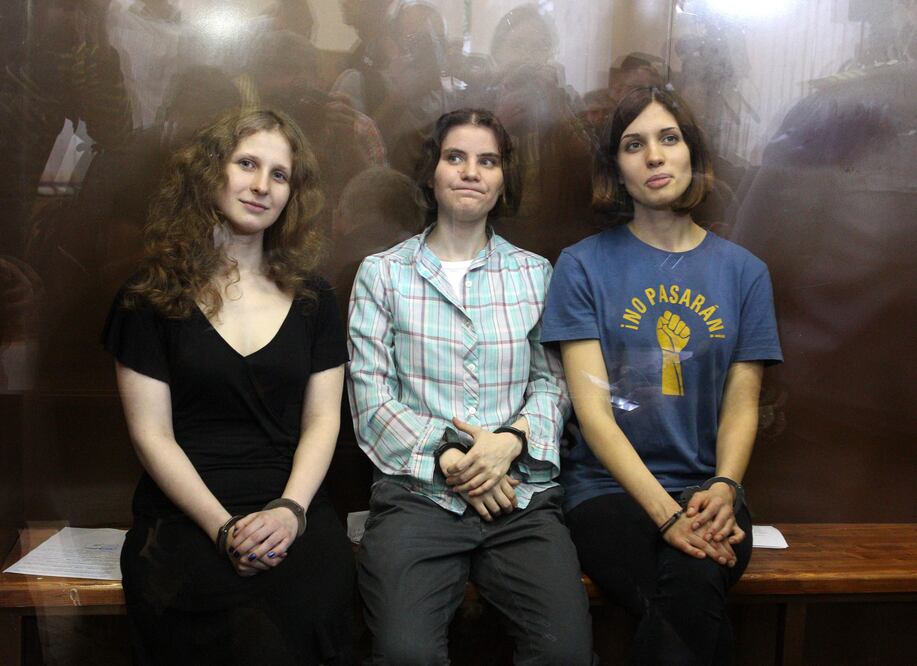 Nadezhda Tolokonnikova (derecha), Maria Alyokhina (izquierda) y Yekaterina Samutsevich sentadas en una celda con paredes de vidrio tras ser condenadas a dos años de prisión por una protesta contra el Kremlin en 2012. Foto: AFP