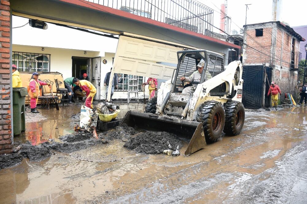 En la calle Rincón de los Lirios, personal de la delegación y del gobierno capitalino acudió en ayuda de los vecinos para retirar el lodo y la basura para mitigar la inundación. (FOTOS: ALONSO ROMERO. EL UNIVERSAL)