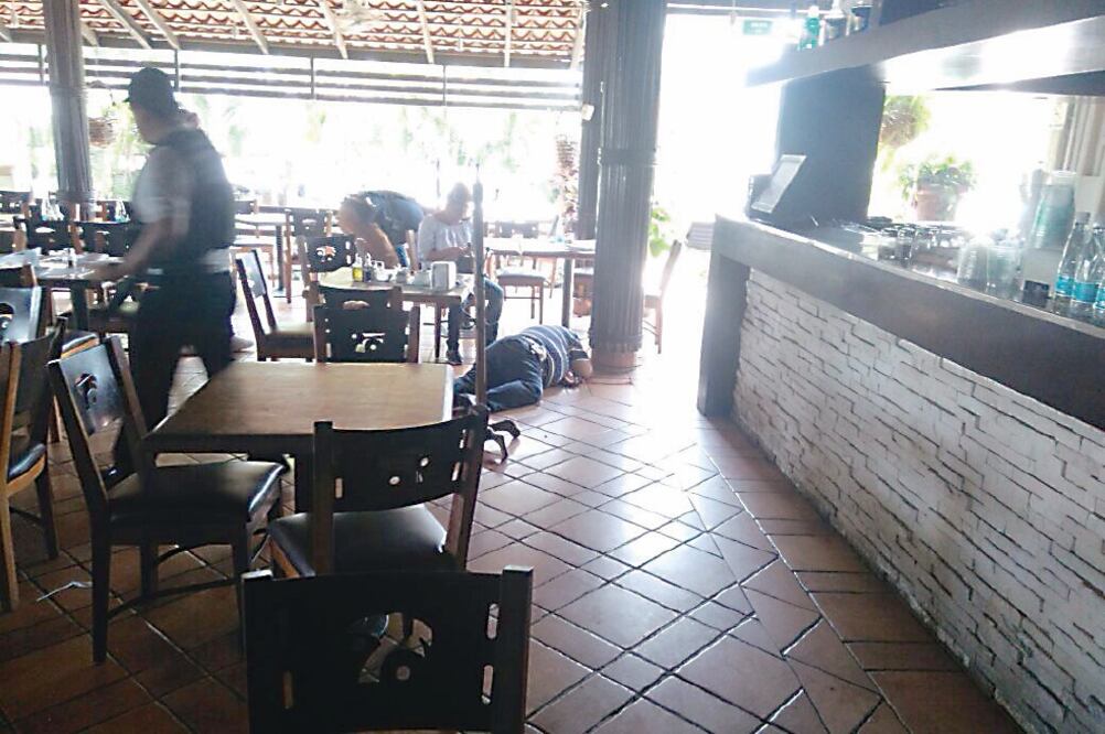 Pánico. El cuerpo del funcionario de la SCT quedó tendido junto a una de las mesas del restaurante, en Acapulco. Foto: CARLOS DE LA FUENTE. EL UNIVERSAL