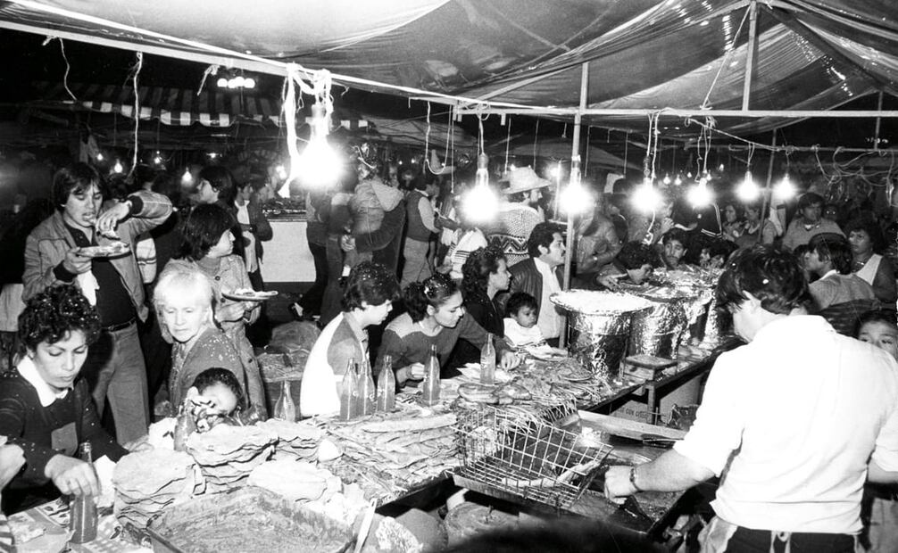 Puesto de antojitos mexicanos en pleno Zócalo Capitalino, la noche del 15 de septiembre de 1985. Estos negocios se ponían desde las 18 horas con cientos de buñuelos, pambazos, tacos y demás platillos, listos para saciar el hambre de los asistentes al festejo patrio. Foto: Jorge González/Archivo EL UNIVERSAL.