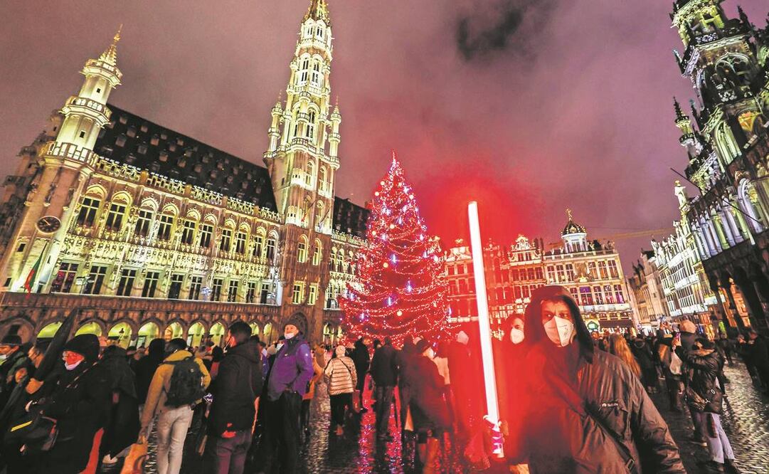Una persona con cubrebocas frente al árbol de Navidad en Bruselas, Bélgica. Foto: Olivier Matthys/ AP.