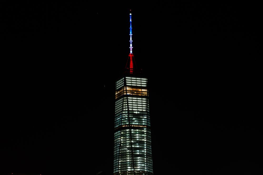 La aguja del One World Trade Center, el rascacielos más alto de EU, se iluminó hoy de azul, blanco y rojo (Xinhua)