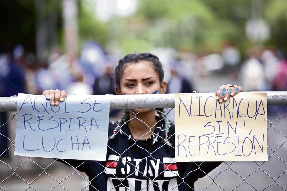 Una joven protesta en las inmediaciones del Seminario de Fátima, donde inició ayer la mesa de diálogo entre el gobierno, empresarios, representantes de la sociedad civil y estudiantes, que demandan la salida del presidente Daniel Ortega. Foto: EFE