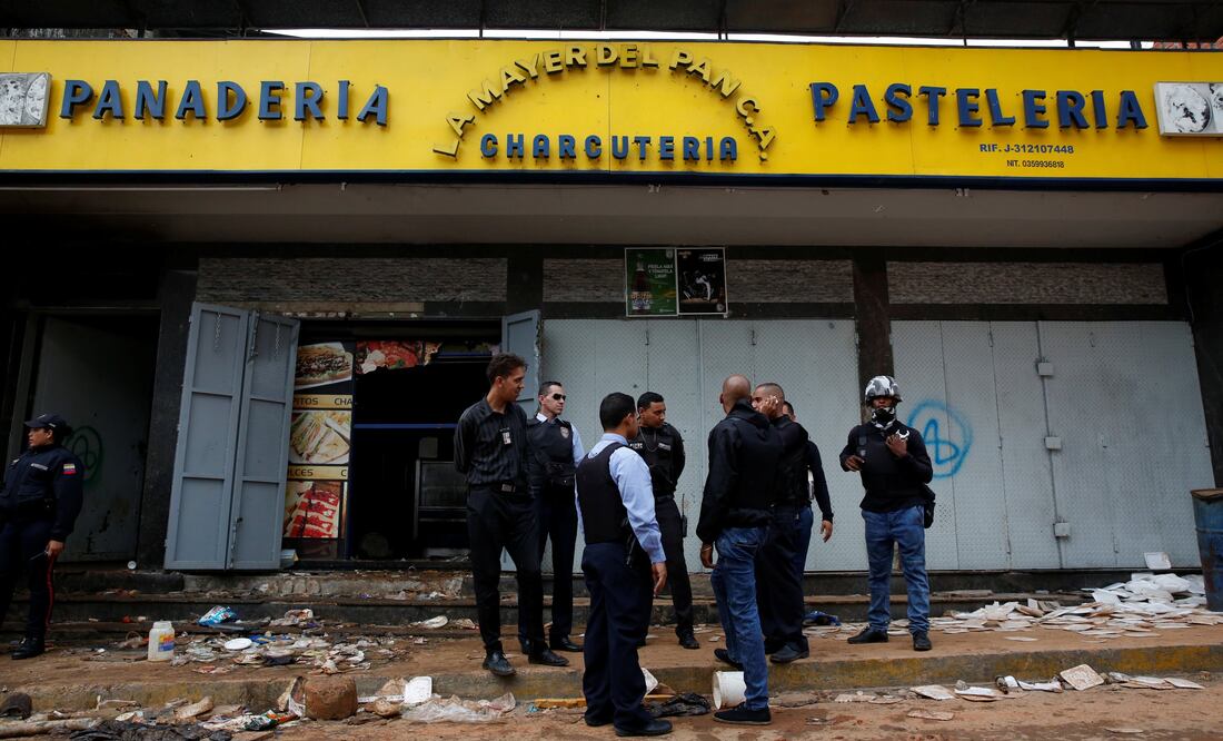 Oficiales de policía e investigadores criminales frente a la panadería en Caracas en la que murieron electrocutadas al menos 8 personas (Foto: Reuters)