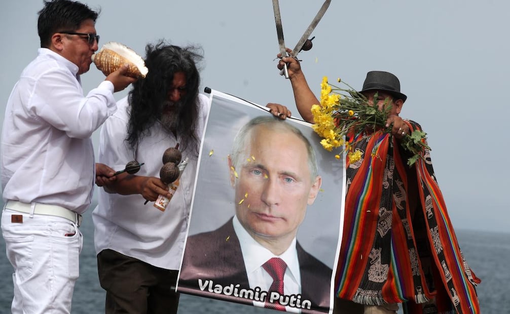 Un grupo de chamanes y curanderos sostienen un cartel con la imagen del presidente de Rusia, Vladimir Putin, durante un ritual de fin de año frente al océano Pacífico este lunes, en Lima (Perú). (29/12/25) Foto: EFE