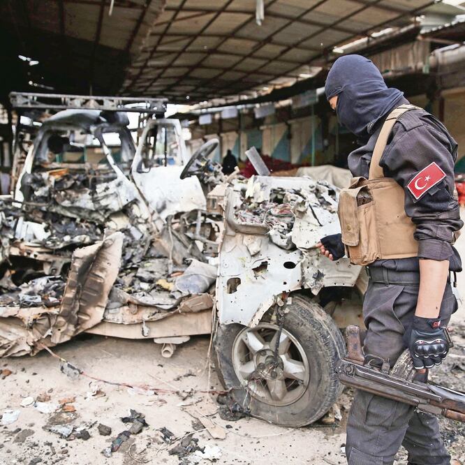 Un policía inspecciona los restos de un automóvil que, según informes, explo tó en un mercado al norte de Siria, matando e hiriendo a varias personas. NAZEER AL-KHATIB. AFP