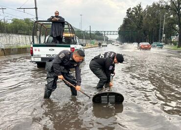 FOTOS. Elementos de la policía ribereña de la SSC destapan coladeras en Calzada Ignacio Zaragoza para evitar vehículos varados en los encharcamientos